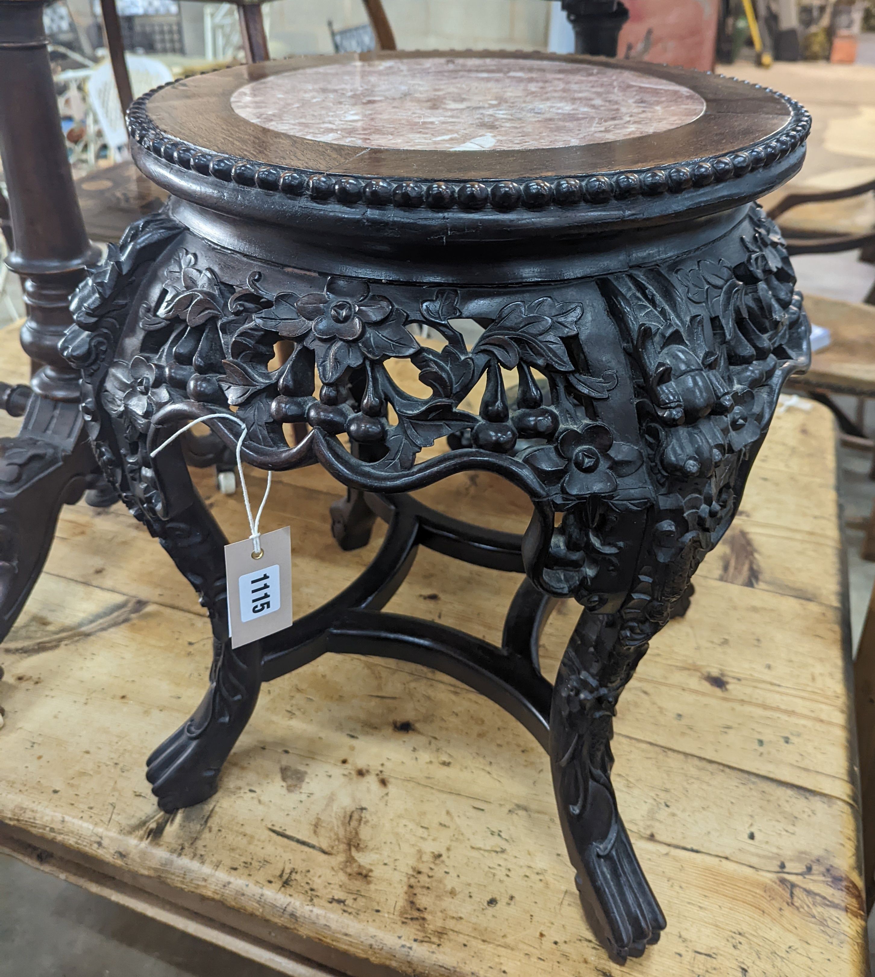 A 19th century Chinese carved hardwood jardiniere stand, with a rouge marble inset top, diameter 46cm, height 50cm